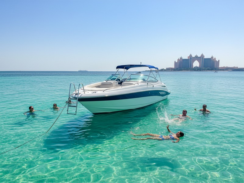 Speed boat anchored swim stop Palm Lagoon Dubai guests swimming clear water